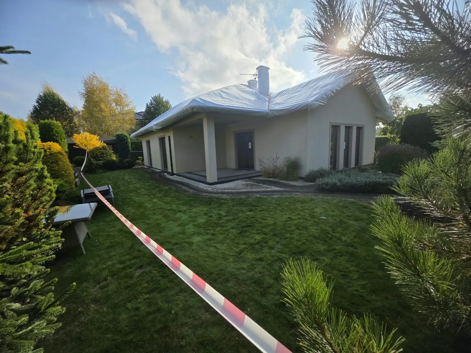 Ogród odgrodzony taśmą ostrzegawczą podczas fumigacji domu w Niemczu